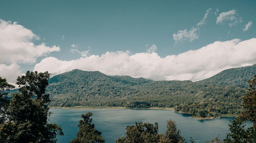 Scenic view of lake by mountains against sky