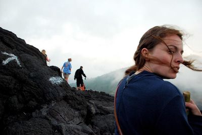 Friends standing on mountain against sky