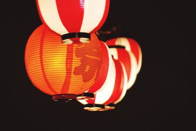 Low angle view of illuminated lantern hanging against black background
