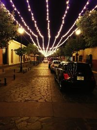 Cars on illuminated street at night