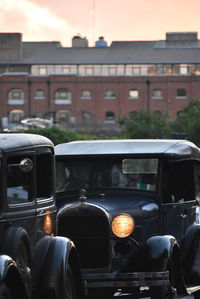 Close-up of cars in city against sky