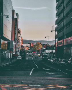 Vehicles on road against buildings in city