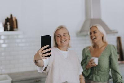 Women taking selfie in kitchen
