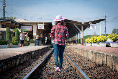 Full length of woman walking on railroad tracks