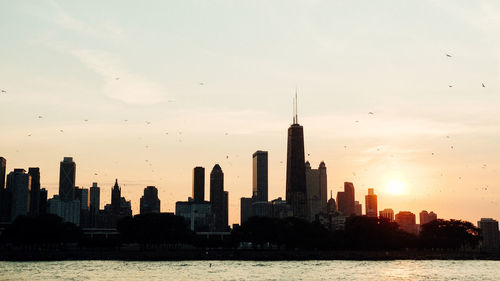 View of buildings in city against sky during sunset