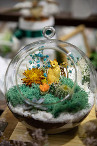 Close-up of flowers in glass container on table