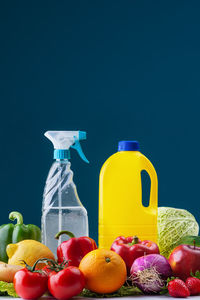 Various fruits on glass against blue background