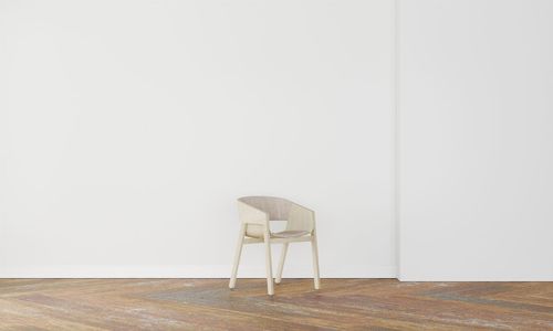 Empty chair on hardwood floor against wall