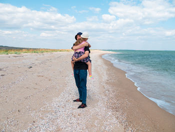 Happy family father daughter hugging marine landscape bearded dad child in hands having fun together