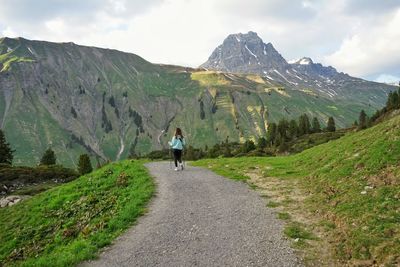 Rear view of man on road against mountain range