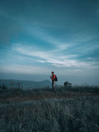 Man standing on field against sky