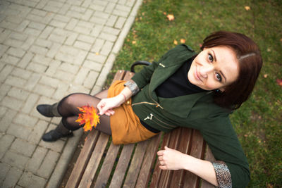 High angle portrait of smiling woman on footpath