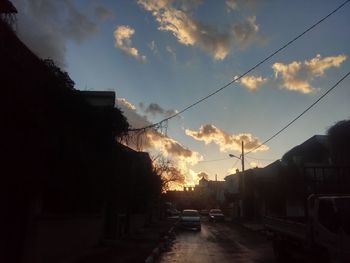 Road passing through city at sunset