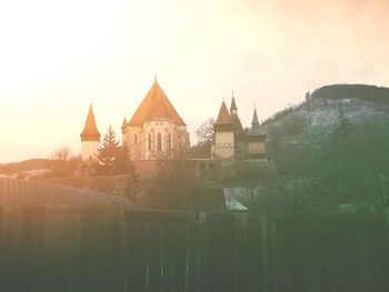 Houses against sky during sunset