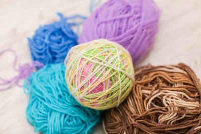 Multi colored ball of wools on wooden table