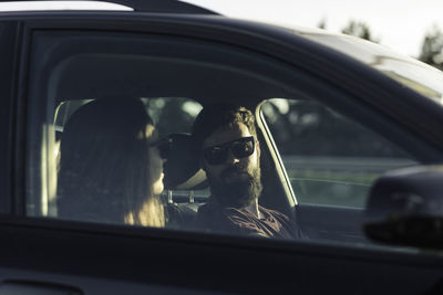 Portrait of man seen through car window