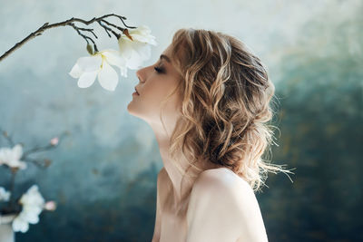 Portrait of woman with pink flowers against blurred background