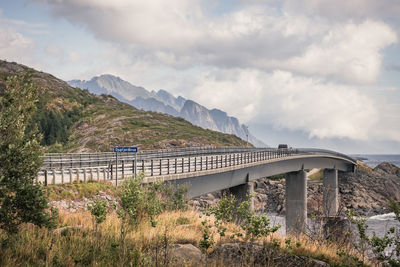 Bridge over mountain against sky