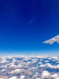 Aerial view of airplane wing against blue sky