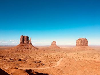 Rock formations in desert against blue sky