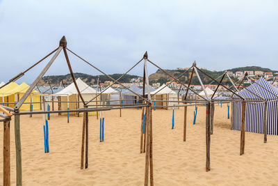 Deck chairs on beach against sky