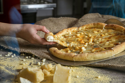 Cropped image of woman hand having pizza at table