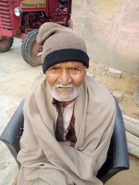 Portrait of man wearing hat sitting outdoors