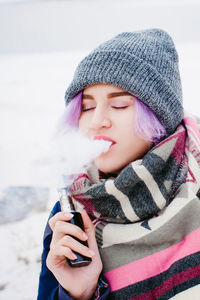 Close-up of young woman smoking outdoors