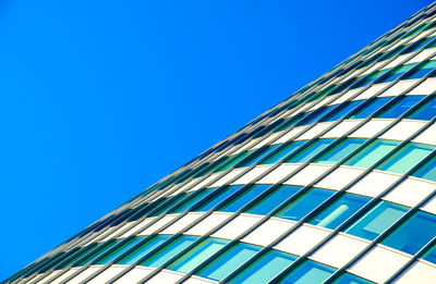 Low angle view of modern building against clear blue sky