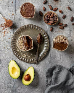 Chocolate cake and fresh avocado scattered on the table