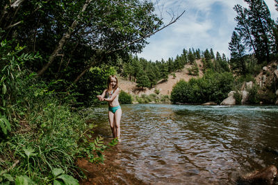 Horizontal portrait of a young girl in a river on a sunny day