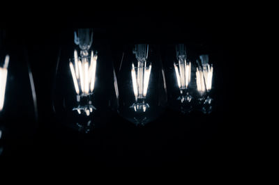 Close-up of illuminated light bulbs in dark room