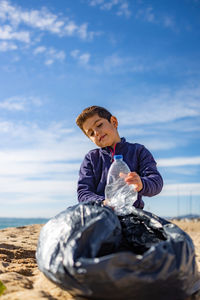 Little kid picking plastic on the beach. recycling concept