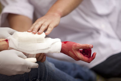 Midsection of nurse examining injured hand
