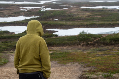 Rear view of man standing on land during winter