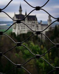 Close-up of barbed wire fence against sky