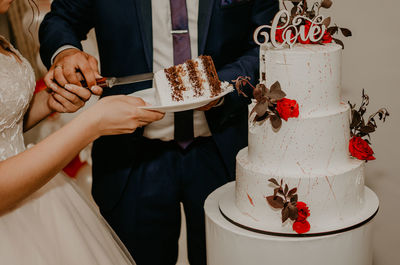 Midsection of bride and woman holding food