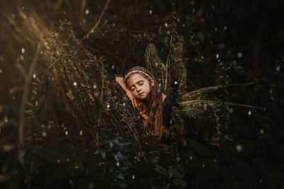 Portrait of woman standing by tree