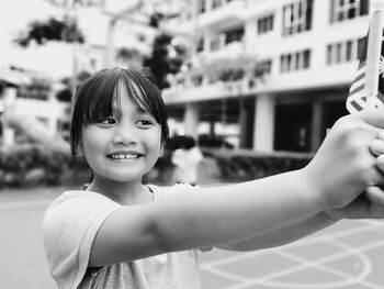 Smiling girl holding malaysian flag in park