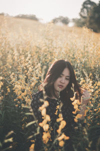 Portrait of woman standing in field
