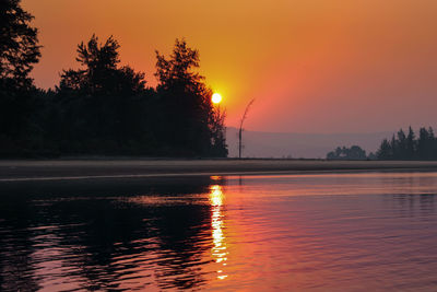 Scenic view of lake against romantic sky at sunset