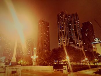 Low angle view of illuminated cityscape against sky at night