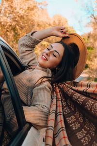 Portrait of young woman sitting in car