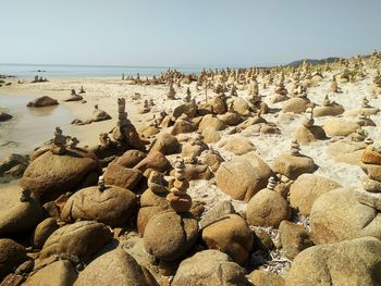 Rocks on beach against clear sky