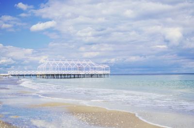 Pier over sea against cloudy sky