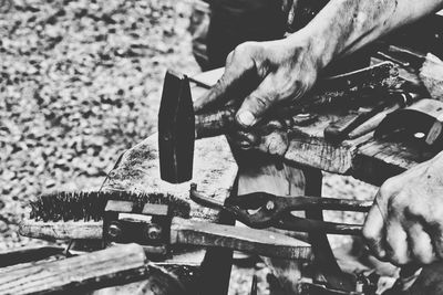 Cropped hands of blacksmith hammering metal at workshop