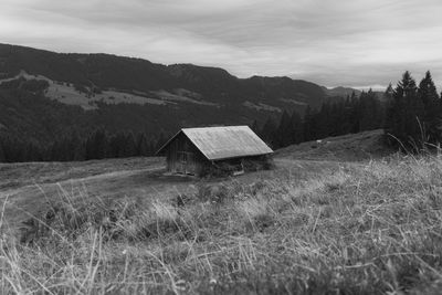 Black and white photo of cabin on meadow in the mountains of allgäu, southern germany