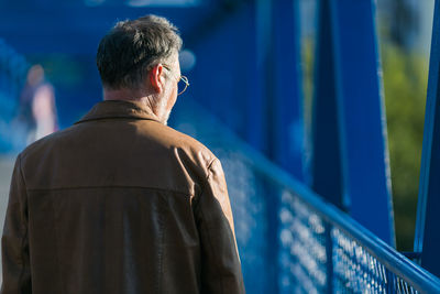 Lonely man walking and looking down from the bridge