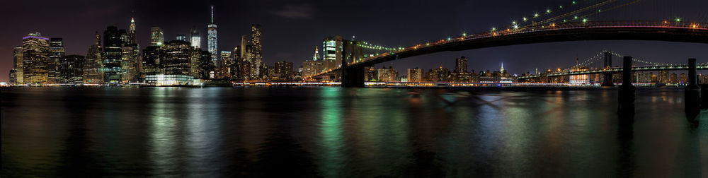 Illuminated bridge over river at night