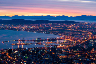 High angle view of illuminated city against sky at sunset